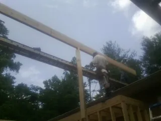 Carpenter setting a ridge beam over a new addition frame — Ice Dam Removal by Roofing Brothers in Craigmont
