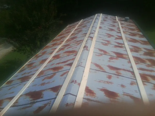Rusted metal roof panels with new wood purlins before replacement — Storm Damage Roof Repair in Craigmont by Roofing Brothers