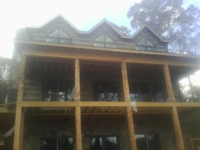 Dormers and porch framing on a large log home under construction — Roof Coating work by our crew in Craigmont