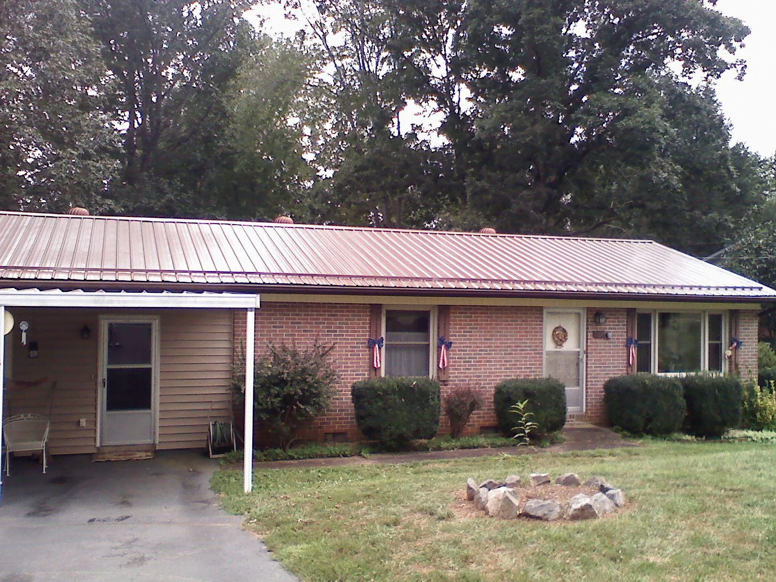 Bronze metal roof and carport on a brick ranch home — Roof Repair work by our crew in Craigmont