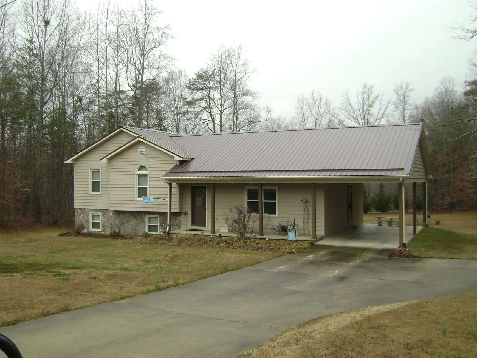 Brown metal roof on a tan split level home with an attached carport in Craigmont